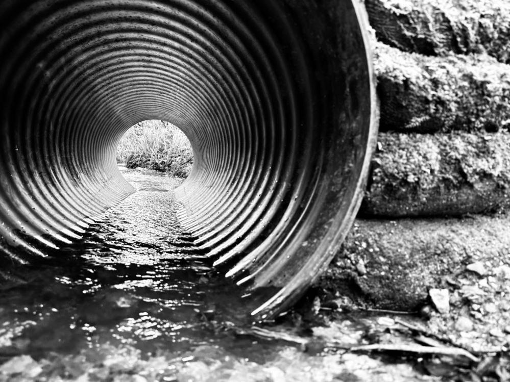 Black and white image of water in a metal pipe