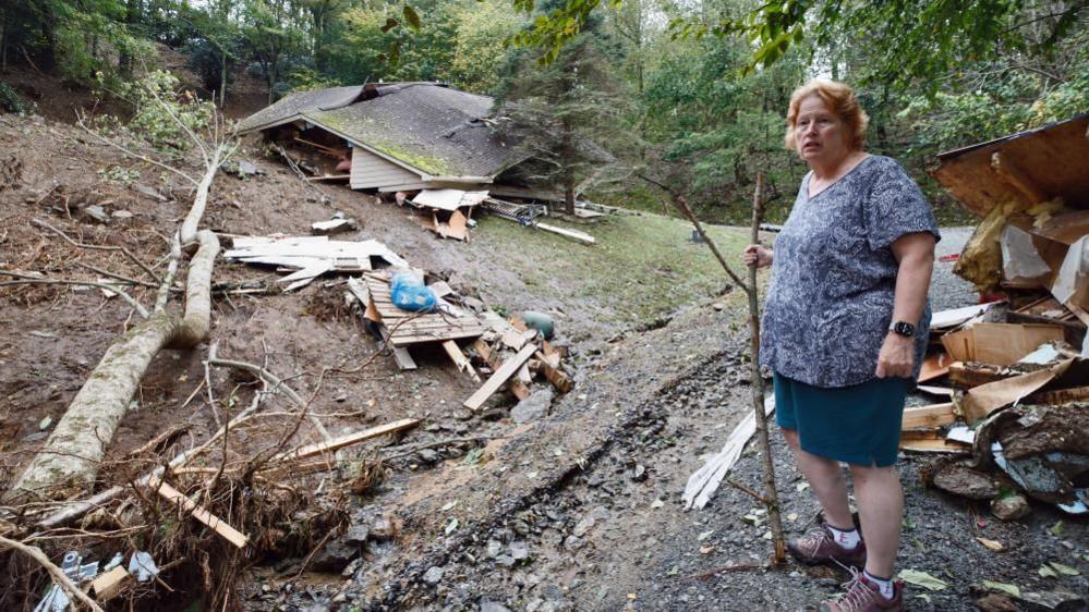 Meta Gatschenberger surveys the remains of her collapsed and destroyed house in North Carolina