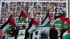 Manifestantes levantam bandeiras nacionais durante um comício na cidade de Ramallah, na Cisjordânia ocupada, em apoio a Gaza e aos prisioneiros palestinos nas prisões israelenses, em 14 de novembro de 2023