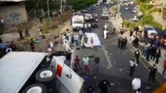 Destroços e dezenas de pessoas e agentes na estrada, perto de carreta tombada