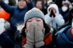 윤석열 대통령 탄핵안 가결 소식에 여성이 입을 가리고 기뻐하고 있다