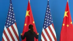 A woman sets up Chinese and US flags in Beijing, 2014