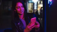 Woman checks phone at a club