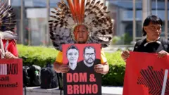 Indígena segura cartaz com ilustrações de Dom e Bruno