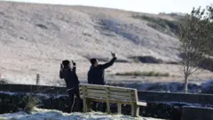 Casal tirando fotos em local com neve em Santa Catarina