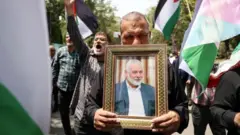 A man carrying a picture of Ismail Haniyeh