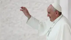 Aparecendo de perfil, Papa Francisco acena sorrindo