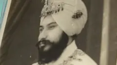 Amrit Kaur (L), the daughter of the late Maharaja of Faridkot- Harinder Singh Brar, poses with a portrait of the Maharaja and her husband Harpal Singh at their residence in Chandigarh on August 2, 2013.