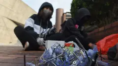 Protesters sit next to nails made to throw near barricades against the police during a protest at the Hong Kong Polytechnic University, in Hong Kong, China, 14 November 2019.