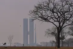 A foto mostra a Esplanada dos Ministérios em Brasília e um céu acinzentando.