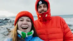 Homem e mulher tirando selfie na neve