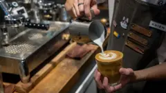 Barista coloca leite em um copo de café