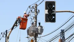 Ténico conserta poste em uma plataforma suspensa