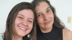 Mãe e filha abraçadas e sorrindo para foto