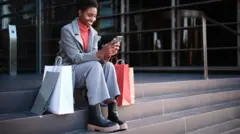 Mulher negra sentada com sacolas de compras