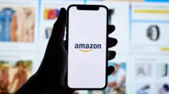 Pessoa segura smartphone com logo da Amazon