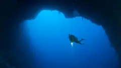 Un buzo en un agujero azul marino