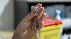 Some vaccine being drawn from a vial into a syringe