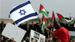 Manifestantes com bandeiras de Israel e Palestina