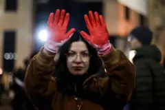 22 Aralık 2024'teki protesto sıradında kırmızıya boyanmış eldivenler giyinen bir kadın. 