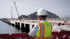 Um operário observa as obras do porto de Chancay.