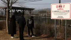 A North Korean defector family pay tribute to ancestors at a spot near the DMZ border