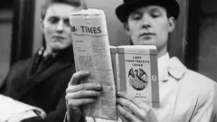 O fotógrafo George Freston posa como passageiro no metrô de Londres, lendo 'Lady Chatterley's Lover', de D. H. Lawrence, no dia em que o livro foi colocado à venda, depois que um júri concluiu que o livro não era uma publicação obscena