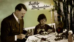 Um cartão de Natal em que Adolf Hitler aparece ao lado de uma menina e uma árvore de Natal