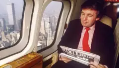 Trump lê jornal em avião