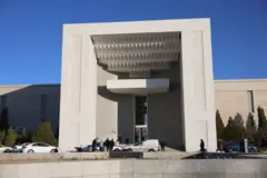 Pessoas caminham em frente à entrada da residência presidencial