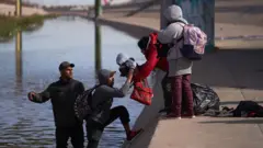 Migrants illegally cross the Rio Grande River to try to turn themselves into US Border Patrol in Juarez City, Mexico, 20 December 2022