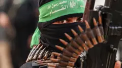 Um membro das Brigadas Izz al-Din al-Qassam, o braço militar do movimento palestino Hamas, participa de um desfile na Cidade de Gaza em 14 de novembro de 2021