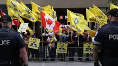 Manifestantes pró-Calistão empunhando bandeiras amarelas durante protesto em Londres