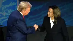 Trump e Kamala dando as mãos