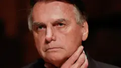 Bolsonaro com olhar sério e mão no pescoço