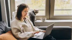 Mulher sentada no sofá usando um laptop