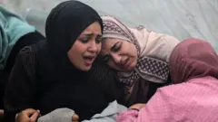 Mulheres no hospital de Al Aqsa velam entes queridos após bombardeio no domingo