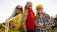 Femmes âgées élégantes souriant joyeusement dans un parc.