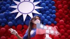 A woman poses for photos in front of a Taiwanese flag made with balloons during a fair to mark the National Day at Zhongzhen New Village Cultural Park on October 10, 2023