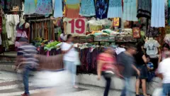 Pessoas andando em rua de São Paulo