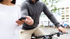 Homem de bicicleta roubando celular