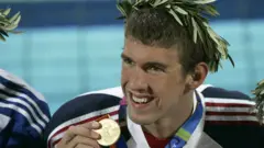 Michael Phelps mostrando sua medalha de ouro