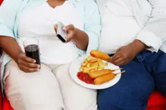 Un couple de personnes en surpoids en train de manger