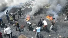 Homens queimando cabos e plásticos no lixão de Agbobloshie