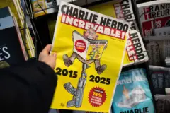 Edição da revista Charlie Hebdo, com as datas 2015 e 2025, e uma pessoa sentada na ponta dee uma arma com a revista aberta em mãos