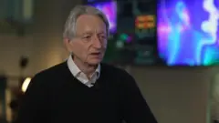 Geoffrey Hinton, um homem branco, idoso, de cabelos brancos e olhos azuis, usando uma blusa preta