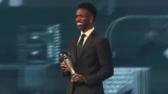 Vini Jr. segurando troféu de melhor jogador do mundo da Fifa