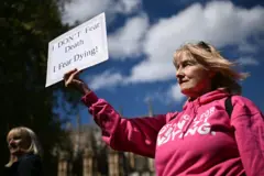 Mulher segurando cartaz em que se lê 'não tenho medo da morte' em protesto a favor da eutanásia e do suicídio assistido