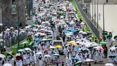 Pessoas chegando ao acampamento Mina de guarda-chuva