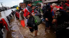 Pessoas sendo resgatadas de barco durante tragédia no Sul